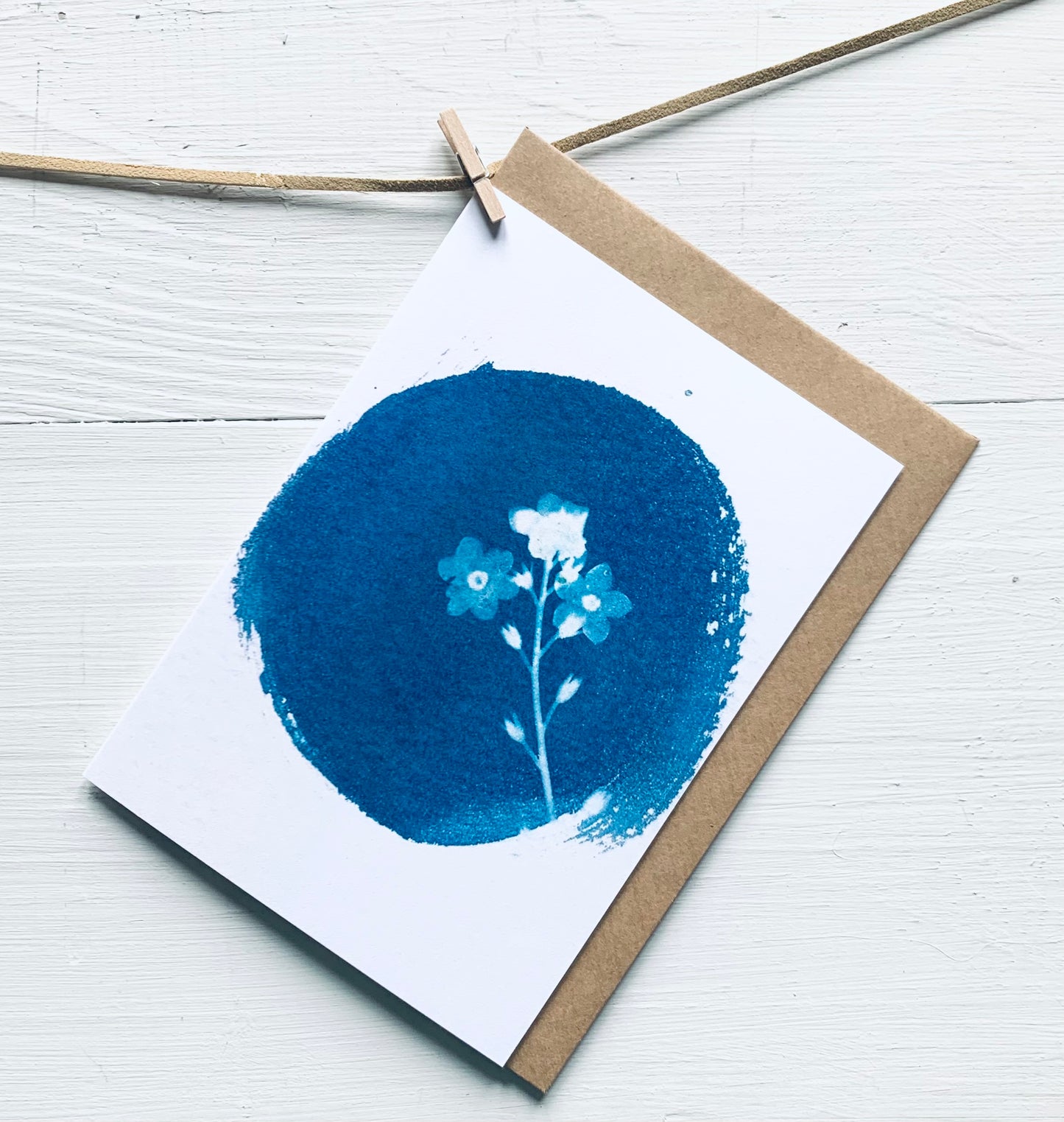 Forget me not flower in a round cyanotype as a greeting card with brown craft envelope